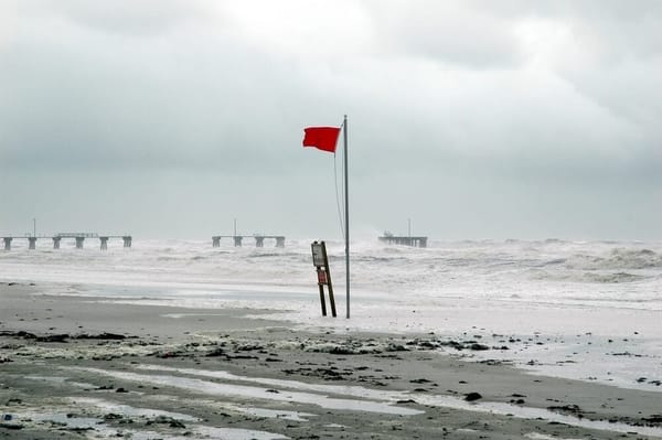 Red flag flying at beach warning of oncoming hurricane