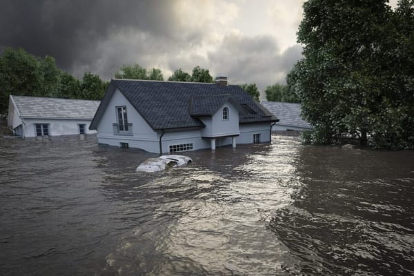 Homes flooded up to the roof of houses with a car under water.